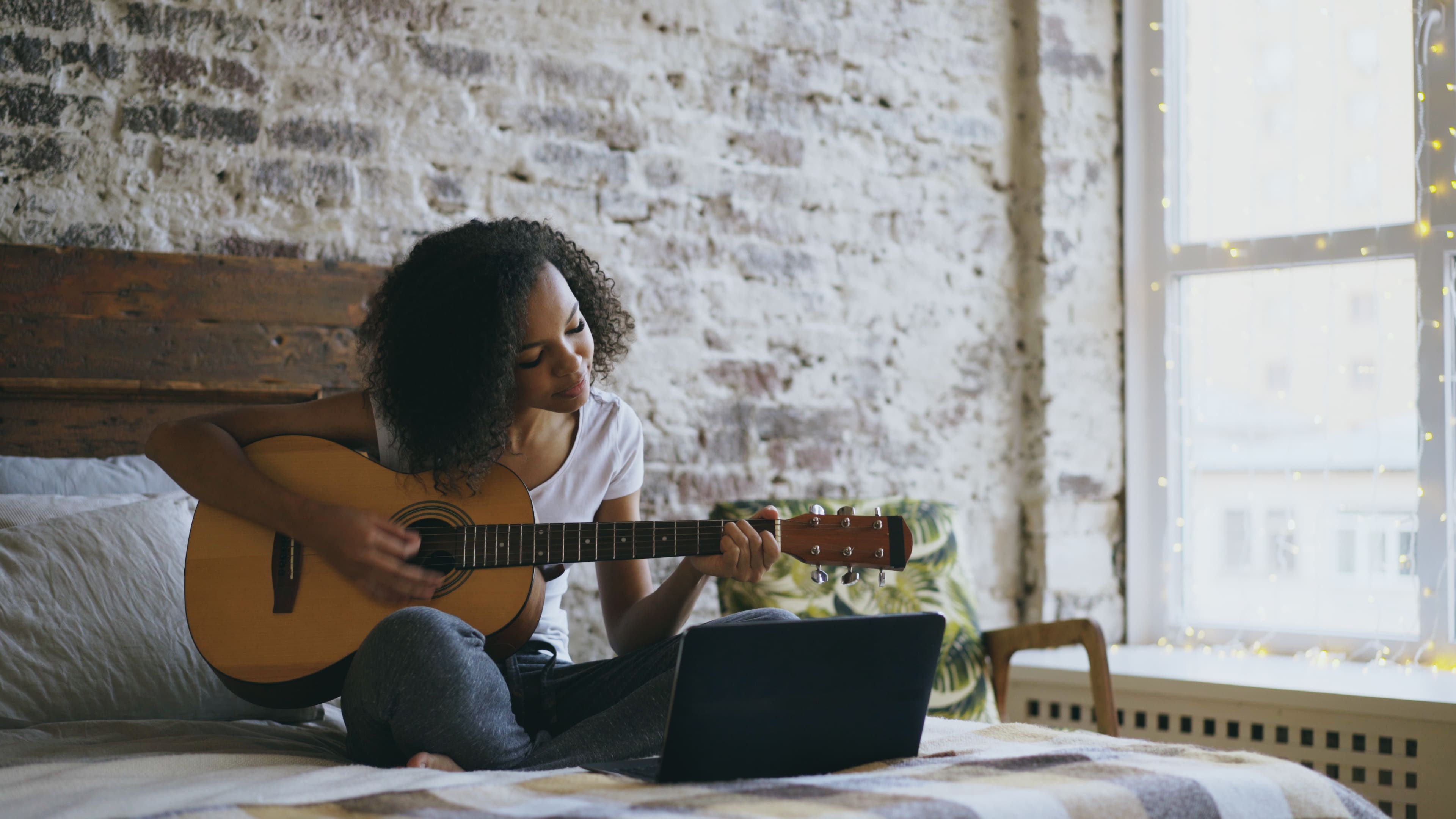 A woman sitting on the floor playing guitar