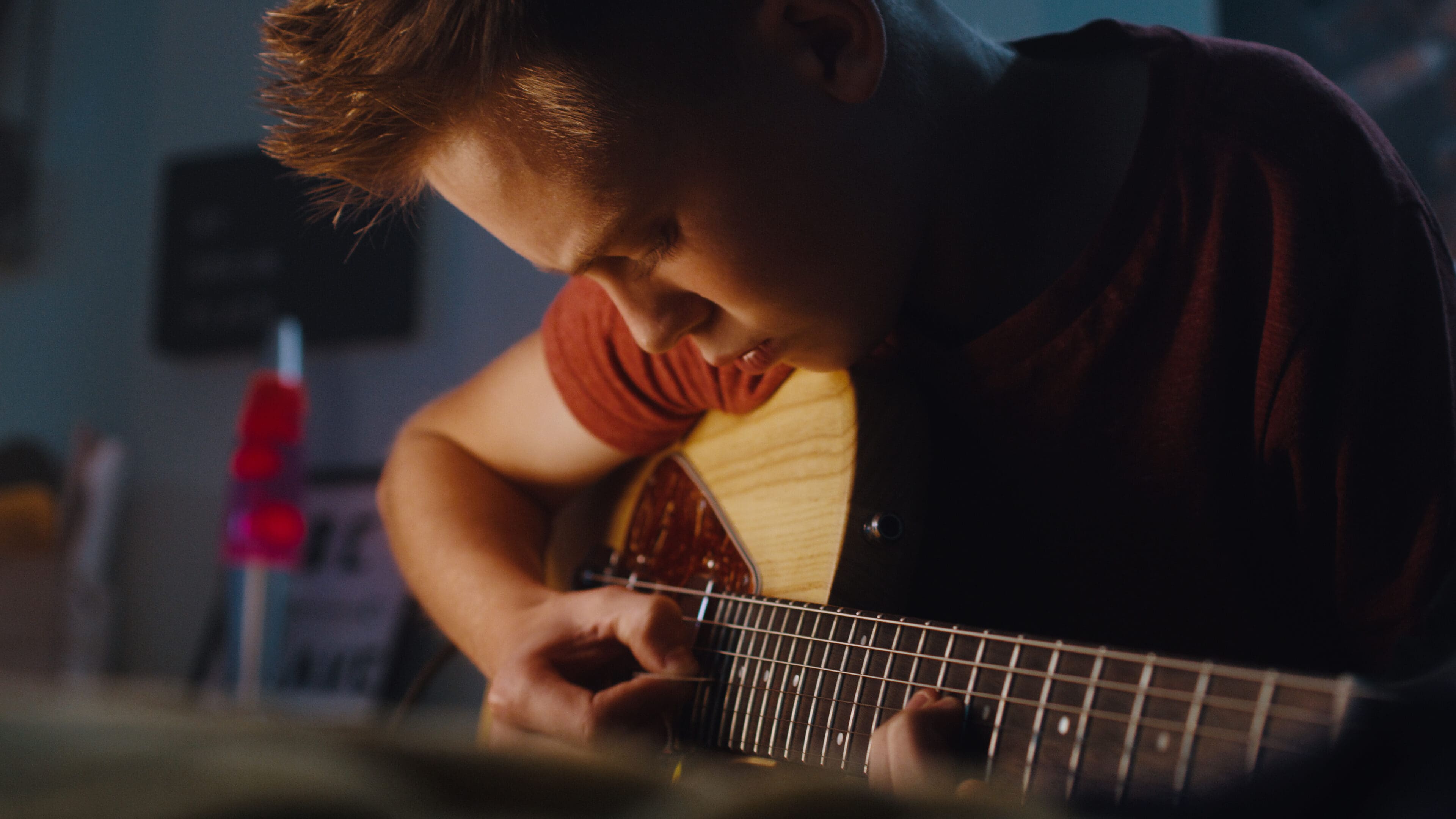 A man playing an instrument in the dark.