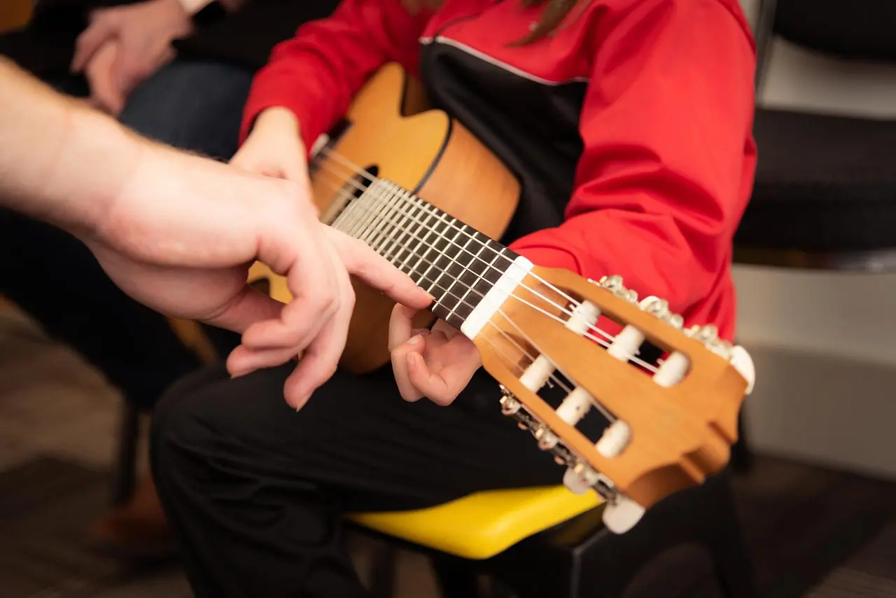 A person playing an instrument while another holds out his hand.