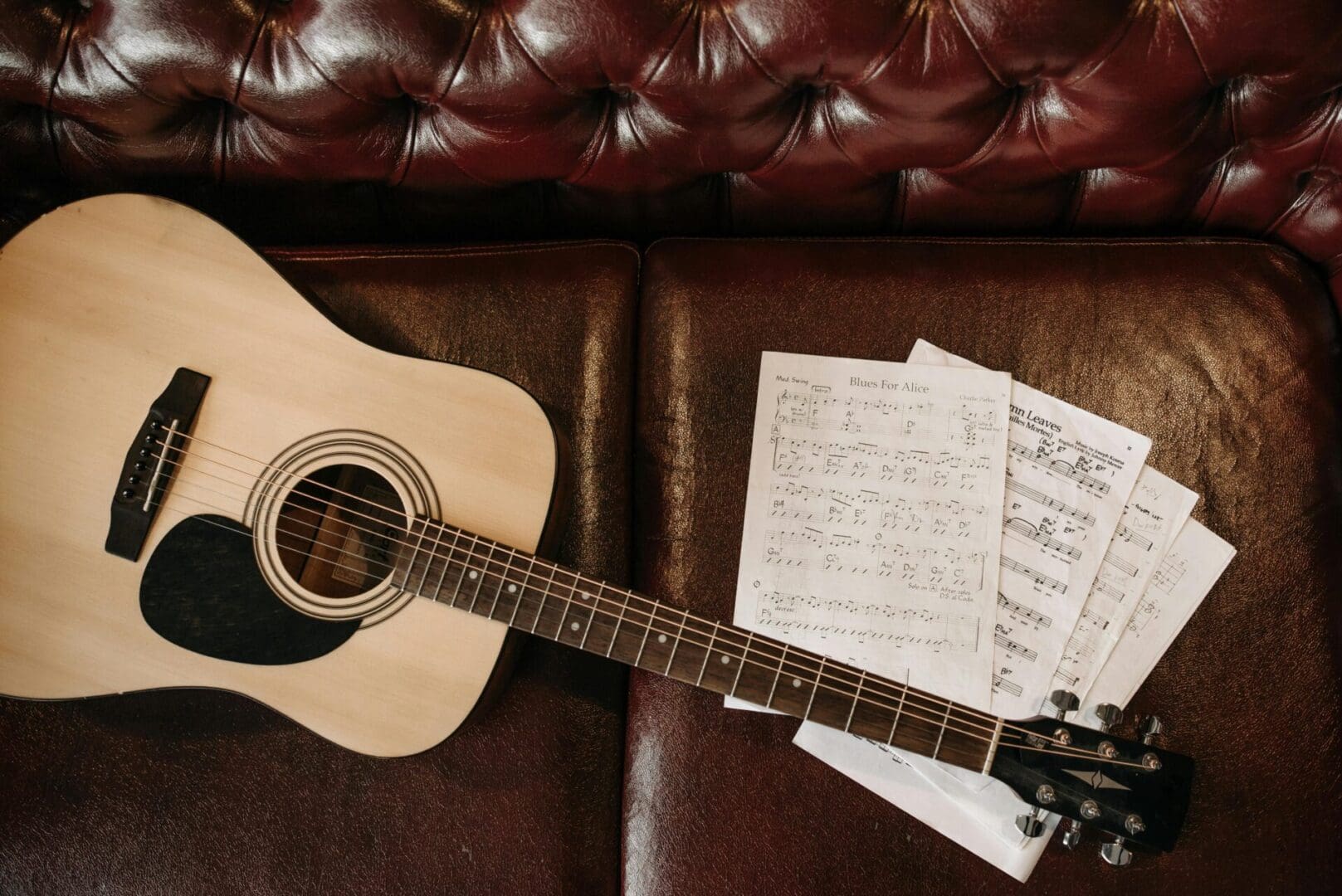 A guitar sitting on top of some sheets of paper.