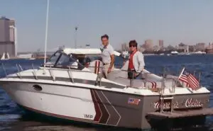 Two men standing on a boat in the water.